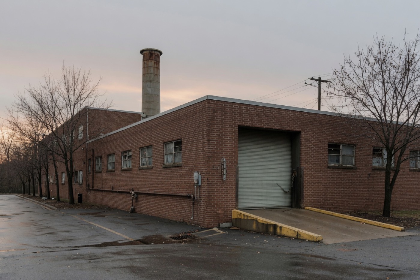 A brick campus plant with a short stack and a roll-up door.
